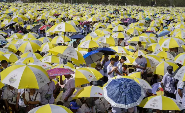 Faithful use umbrellas with the colors of the Vatican flag to shield themselves from the sun as they wait for a mass presided over by Pope Francis to start in Tasitolu, some 8 kilometers west of Dili, East Timor, Tuesday, Sept. 10, 2024. Pope Francis presides over a mass in a seaside park on the same field where St. John Paul II celebrated a historic liturgy during East Timor's fight for independence from Indonesian rule. (AP Photo/Gregorio Borgia)