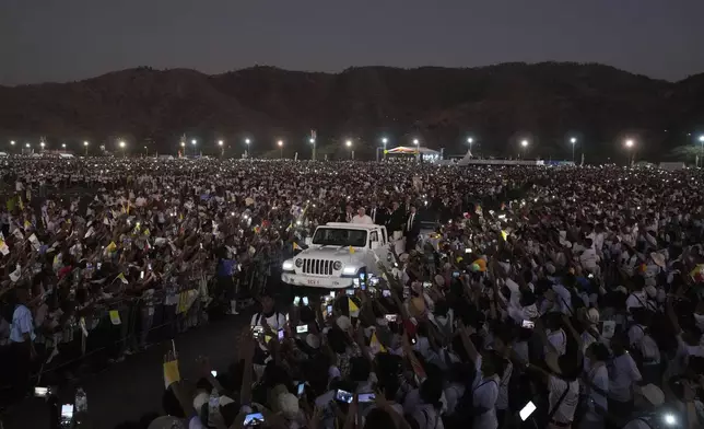 Pope Francis leaves after leading a holy mass at Tasitolu park in Dili, East Timor, Tuesday, Sept. 10, 2024. With half of East Timor's population gathered at a seaside park, Francis couldn't help but oblige them with a final good night and languid loops in his popemobile, long after the sun had set and cellphone screens lighted the field. (AP Photo/Firdia Lisnawati)