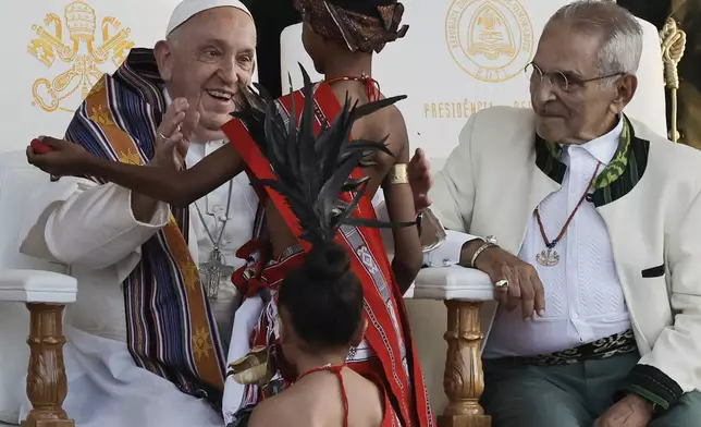 Pope Francis greets youths in traditional dress as East Timor's President Jose Ramos-Horta looks on during a welcoming ceremony at the Presidential Palace in Dili, East Timor, Monday Sept. 9, 2024. In East Timor Francis had to negotiate perhaps the most sensitive issue clouding the visit to Asia and Oceania : the case of Bishop Carlos Ximenes Belo, the revered national hero who won the Nobel Peace Prize for his nonviolent independence campaign. (Yasuyoshi Chiba/Pool Photo via AP)