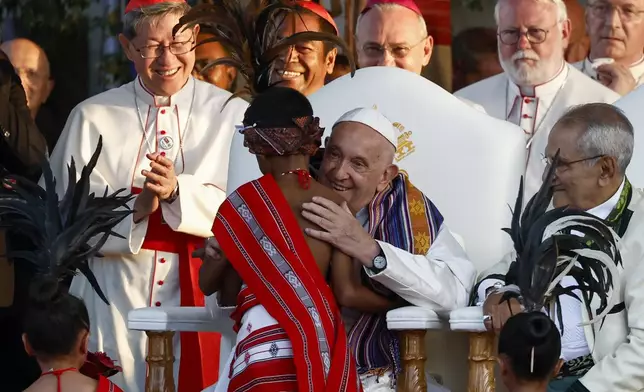 Pope Francis hugs a child as East Timor President Jose Ramos-Horta sits with him during a welcoming ceremony upon meeting at the Presidential Palace in Dili, East Timor, Sept.9, 2024. In East Timor Francis had to negotiate perhaps the most sensitive issue clouding the visit to Asia and Oceania : the case of Bishop Carlos Ximenes Belo, the revered national hero who won the Nobel Peace Prize for his nonviolent independence campaign. (Willy Kurniawan/Pool Photo via AP)