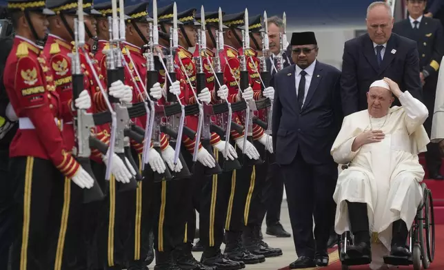 Pope Francis is welcomed by Indonesia's Minister for Religious Affairs Yaqut Cholil Qoumas, center, soon after landing at Jakarta's International airport Soekarno Hatta, Tuesday, Sept. 3, 2024. (AP Photo/Gregorio Borgia)