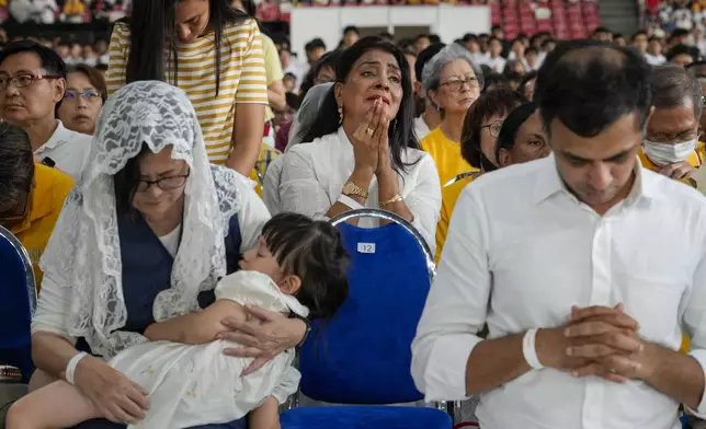 The faithful follow Pope Francis presiding over a mass at the Singapore SportsHub National Stadium, Thursday, Sept. 12, 2024. (AP Photo/Gregorio Borgia)