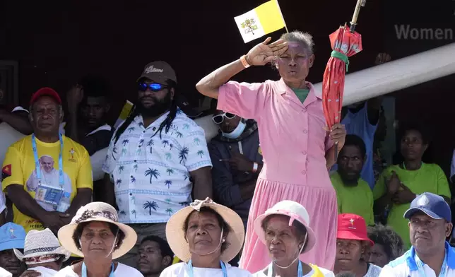 A woman stands as Pope Francis gives an address during a meeting in the Sir John Guise Stadium in Port Moresby, Papua New Guinea, Monday, Sept. 9, 2024. (AP Photo/Mark Baker)