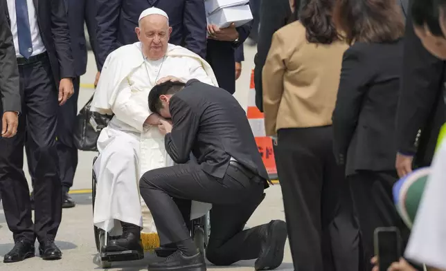 A man kneels before Pope Francis as he is farewelled at Jakarta Soekarno-Hatta International Airport, Indonesia, Friday, Sept. 6, 2024. (AP Photo/Tatan Syuflana,Pool)