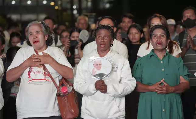 Faithful react as they watch the live screening of the holy mass lead by Pope Francis, outside the Gelora Bung Karno Stadium, in Jakarta, Indonesia, Thursday, Sept. 5, 2024. (AP Photo/Tatan Syuflana)