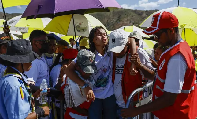 Medical workers carry a person waiting to attend a Holy Mass that will be presided by Pope Francis at the Esplanade of Taci Tolu in Dili, East Timor, Tuesday, Sept.10, 2024. (Willy Kurniawan/Pool Photo via AP)