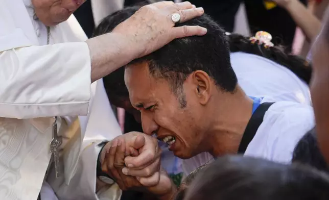 Pope Francis consoles a person during a visit at the 'Irmas ALMA' (Sisters of the Association of Lay Missionaries) School for Children with Disabilities in Dili, East Timor, Tuesday, Sept. 10, 2024. (AP Photo/Gregorio Borgia)