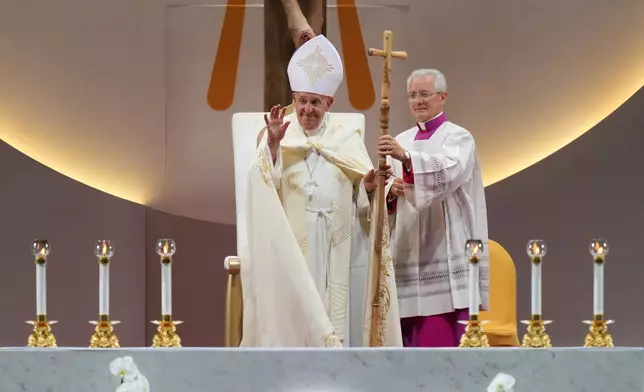 Pope Francis gestures to attendees after presiding over a holy mass at the SportsHub National Stadium in Singapore, Thursday, Sept. 12, 2024. (AP Photo/Vincent Thian)