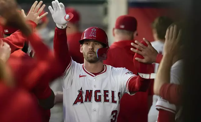 Los Angeles Angels' Taylor Ward (3) celebrates in the dugout after scoring off of a single hit by Nolan Schanuel during the first inning of a baseball game against the Houston Astros in Anaheim, Calif., Saturday, Sept. 14, 2024. (AP Photo/Ashley Landis)