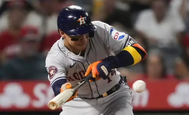 Houston Astros' Mauricio Dubón (14) bunt pops out during the third inning of a baseball game against the Los Angeles Angels in Anaheim, Calif., Friday, Sept. 13, 2024. (AP Photo/Ashley Landis)