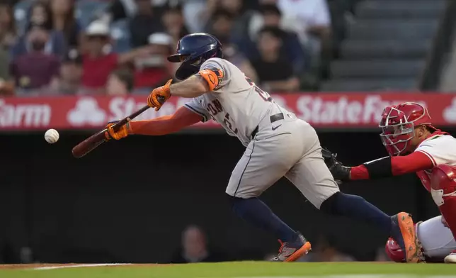 Houston Astros' Jose Altuve singles on a bunt during the first inning of a baseball game against the Los Angeles Angels in Anaheim, Calif., Saturday, Sept. 14, 2024. (AP Photo/Ashley Landis)