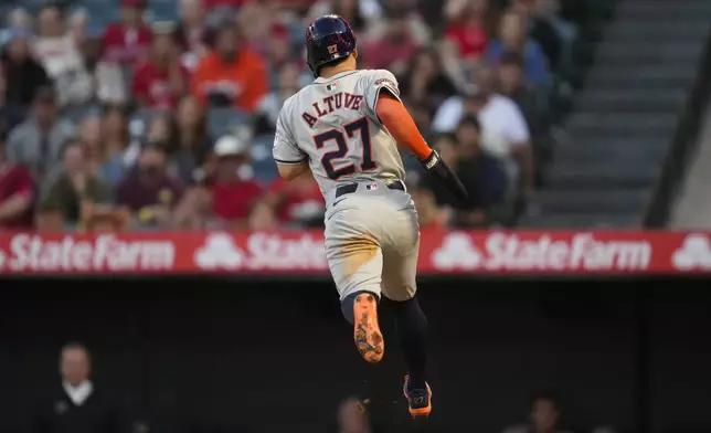 Houston Astros' Jose Altuve (27) scores off of a wild pitch from Los Angeles Angels starting pitcher Tyler Anderson during the first inning of a baseball game in Anaheim, Calif., Saturday, Sept. 14, 2024. (AP Photo/Ashley Landis)