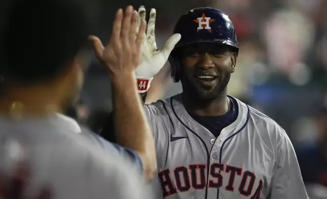 Houston Astros designated hitter Yordan Alvarez celebrates in the dugout after hitting a home run during the fifth inning of a baseball game against the Los Angeles Angels in Anaheim, Calif., Saturday, Sept. 14, 2024. Jose Altuve also scored. (AP Photo/Ashley Landis)