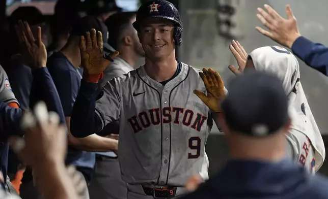 Houston Astros' Zach Dezenzo (9) is congratulated in the dugout after hitting a home run in the fifth inning of a baseball game against the Cleveland Guardians in Cleveland, Friday, Sept. 27, 2024. (AP Photo/Sue Ogrocki)