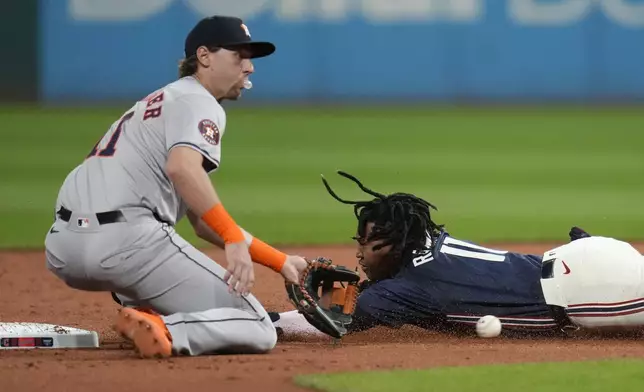 Cleveland Guardians' Jose Ramirez, right, steals second base as Houston Astros third baseman Grae Kessinger, left, takes the throw in the first inning of a baseball game in Cleveland, Friday, Sept. 27, 2024. (AP Photo/Sue Ogrocki)