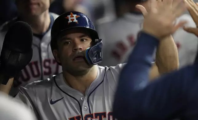 Houston Astros' Jose Altuve is congratulated in the dugout after scoring in the first inning of a baseball game against the Cleveland Guardians in Cleveland, Friday, Sept. 27, 2024. (AP Photo/Sue Ogrocki)