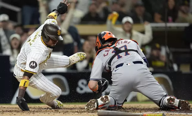 San Diego Padres' Luis Arraez, left, is tagged out by Houston Astros catcher Victor Caratini, after trying to score from second base on a single by Jurickson Profar during the fifth inning of a baseball game Monday, Sept. 16, 2024, in San Diego. (AP Photo/Gregory Bull)