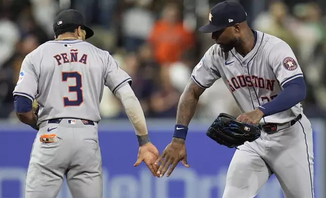 Houston Astros shortstop Jeremy Pena (3) celebrates with right fielder Jason Heyward after the Astros defeated the San Diego Padres 4-3 in a baseball game Tuesday, Sept. 17, 2024, in San Diego. (AP Photo/Gregory Bull)