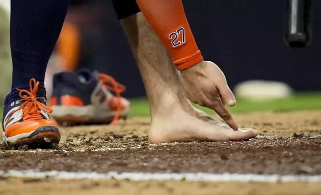 Houston Astros' Jose Altuve points at his foot after taking his sock and shoe off during the ninth inning of a baseball game against the San Diego Padres Tuesday, Sept. 17, 2024, in San Diego. Altuve was ejected along with Astros manager Joe Espada after arguing a groundout by Altuve was fouled off his foot. (AP Photo/Gregory Bull)