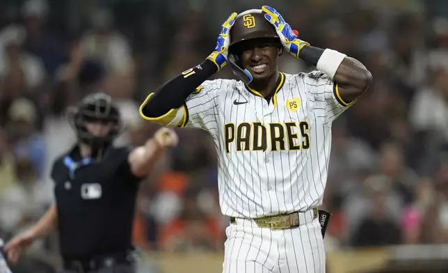 San Diego Padres' Jurickson Profar reacts after getting hit by a pitch during the tenth inning of a baseball game against the Houston Astros Tuesday, Sept. 17, 2024, in San Diego. (AP Photo/Gregory Bull)