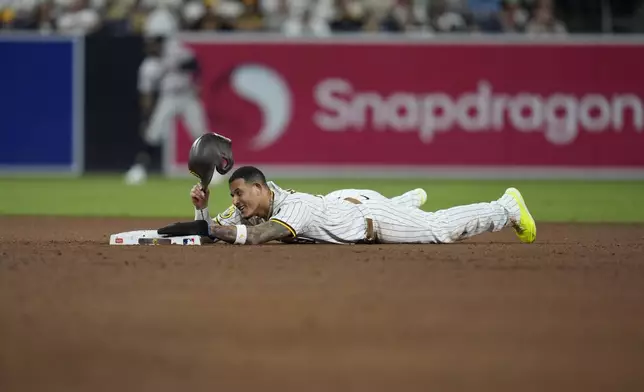 San Diego Padres' Manny Machado takes off his helmet after getting caught stealing second base during the eighth inning of a baseball game against the Houston Astros Monday, Sept. 16, 2024, in San Diego. (AP Photo/Gregory Bull)