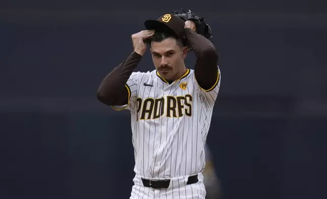 San Diego Padres starting pitcher Dylan Cease adjusts his hat as he works against a Houston Astros batter during the first inning of a baseball game Wednesday, Sept. 18, 2024, in San Diego. (AP Photo/Gregory Bull)