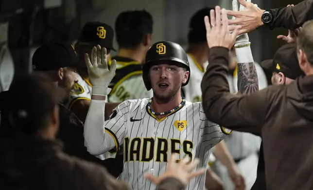 San Diego Padres' Jackson Merrill celebrates in the dugout after hitting a home run during the fourth inning of a baseball game against the Houston Astros, Monday, Sept. 16, 2024, in San Diego. (AP Photo/Gregory Bull)