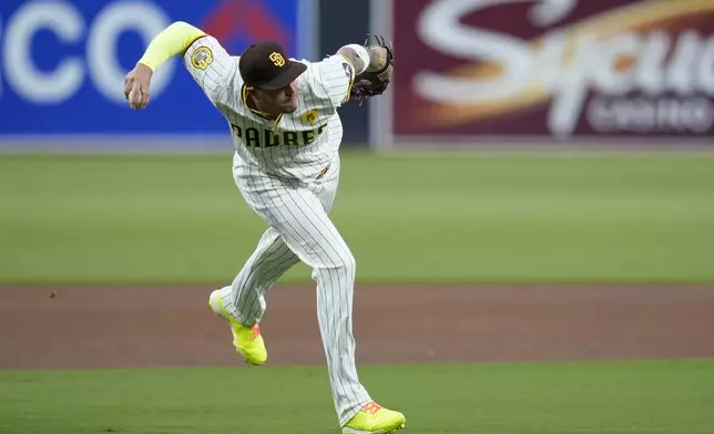 San Diego Padres third baseman Manny Machado throws to first too late as Houston Astros' Jose Altuve arrives for a single during the first inning of a baseball game Tuesday, Sept. 17, 2024, in San Diego. (AP Photo/Gregory Bull)