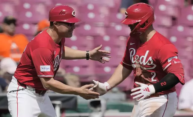 Cincinnati Reds' Ty France, right, celebrates with third base coach J.R. House as he rounds the bases after hitting a home run during the seventh inning of a baseball game against the Houston Astros, Thursday, Sept. 5, 2024, in Cincinnati. (AP Photo/Carolyn Kaster)