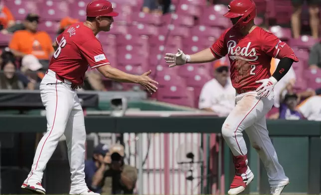 Cincinnati Reds' Ty France, right, celebrates with third base coach J.R. House as he rounds the bases after hitting a home run during the seventh inning of a baseball game against the Houston Astros, Thursday, Sept. 5, 2024, in Cincinnati. (AP Photo/Carolyn Kaster)