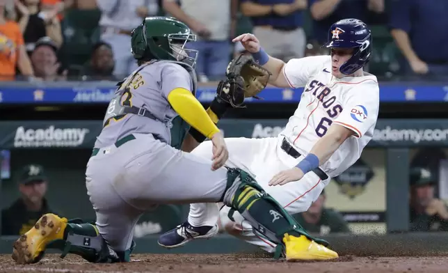 Houston Astros center fielder Jake Meyers (6) beats the throw to Oakland Athletics catcher Shea Langeliers, left, as he scores on an RBI single by Mauricio Dubon during the ninth inning of a baseball game Thursday, Sept. 12, 2024, in Houston. (AP Photo/Michael Wyke)