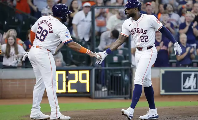 Houston Astros' Jon Singleton (28) and Jason Heyward (22) celebrate after they both scored on the two-run home run by Heyward against the Oakland Athletics during the second inning of a baseball game Thursday, Sept. 12, 2024, in Houston. (AP Photo/Michael Wyke)