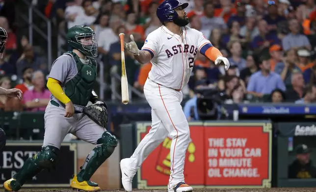 Houston Astros' Jon Singleton, right, watches his one-run RBI triple in front of Oakland Athletics catcher Shea Langeliers, left, during the seventh inning of a baseball game, Tuesday, Sept. 10, 2024, in Houston. (AP Photo/Michael Wyke)