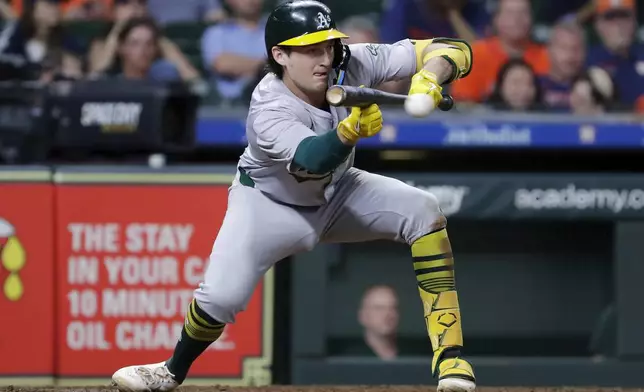 Oakland Athletics' Jacob Wilson lays down a sacrifice bunt against the Houston Astros during the 10th inning of a baseball game Tuesday, Sept. 10, 2024, in Houston. (AP Photo/Michael Wyke)