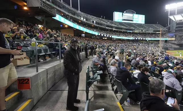 Charles Riley, center, watches after section 122 during a baseball game between the New York Yankees and the Oakland Athletics, Saturday, Sept. 21, 2024, in Oakland, Calif. (AP Photo/Godofredo A. Vásquez)