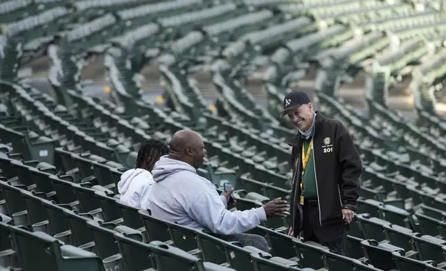 Leland Anderson, right, chats with fans attending a baseball game between the Colorado Rockies and the Oakland Athletics, Wednesday, May 22, 2024, in Oakland, Calif. (AP Photo/Godofredo A. Vásquez)