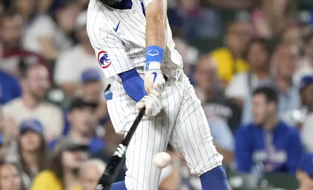 Chicago Cubs' Dansby Swanson hits an RBI single off Oakland Athletics relief pitcher Hogan Harris during the third inning of a baseball game Monday, Sept. 16, 2024, in Chicago. (AP Photo/Charles Rex Arbogast)