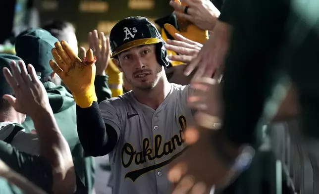 Oakland Athletics' Brent Rooker is greeted in the dugout after his two-run home run off Chicago Cubs starting pitcher Shota Imanaga during the third inning of a baseball game Monday, Sept. 16, 2024, in Chicago. (AP Photo/Charles Rex Arbogast)