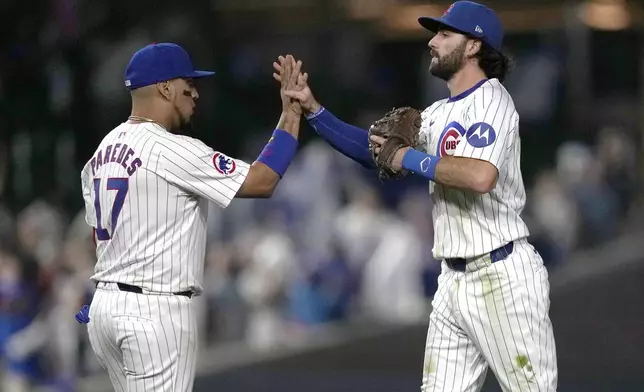 Chicago Cubs' Isaac Paredes, left, and Dansby Swanson celebrate the team's 9-2 win over the Oakland Athletics after a baseball game Monday, Sept. 16, 2024, in Chicago. (AP Photo/Charles Rex Arbogast)