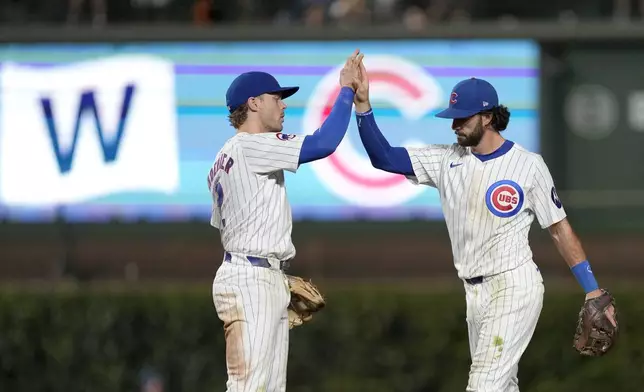 Chicago Cubs' Nico Hoerner, left, and Dansby Swanson celebrate the team's 9-2 win over the Oakland Athletics after a baseball game Monday, Sept. 16, 2024, in Chicago. (AP Photo/Charles Rex Arbogast)