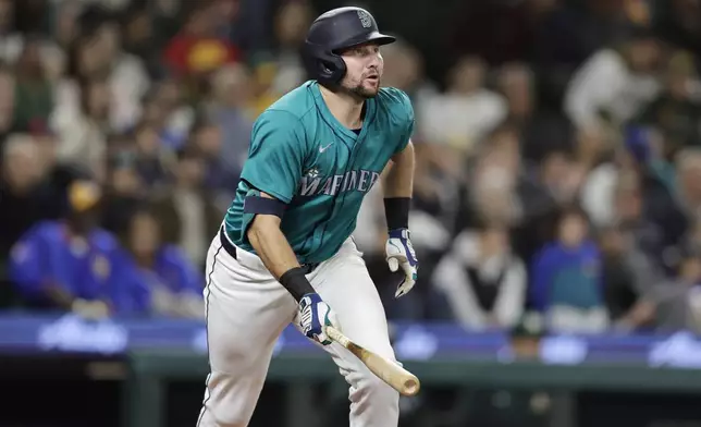 Seattle Mariners' Cal Raleigh watches the flight of his solo home run off Oakland Athletics starting pitcher Joey Estes during the fourth inning in a baseball game, Saturday, Sept. 28, 2024, in Seattle. (AP Photo/John Froschauer)