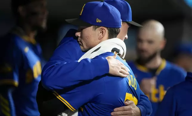 Seattle Mariners starting pitcher Bryan Woo gets a hug from pitcher George Kirby during the fifth inning of a baseball game against the Oakland Athletics, Friday, Sept. 27, 2024, in Seattle. (AP Photo/Lindsey Wasson)