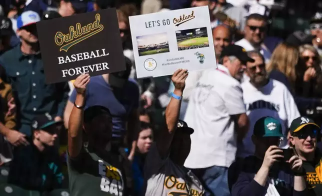 Fans hold signs for the Oakland Athletics before a baseball game between the Athletics and the Seattle Mariners, Sunday, Sept. 29, 2024, in Seattle. (AP Photo/Lindsey Wasson)