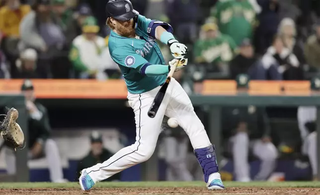 Seattle Mariners' Justin Turner hits an RBI single during the 10th inning against the Oakland Athletics to win 7-6 in a baseball game, Saturday, Sept. 28, 2024, in Seattle. (AP Photo/John Froschauer)