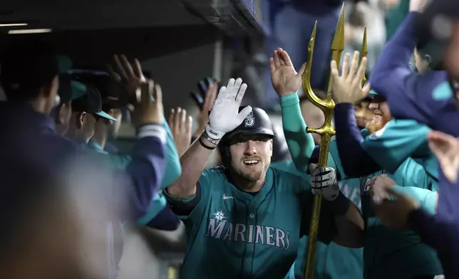 Seattle Mariners' Luke Raley celebrates in the dugout after his two-run home run hit on a pitch from Oakland Athletics pitcher Mason Miller during the ninth inning in a baseball game, Saturday, Sept. 28, 2024, in Seattle. (AP Photo/John Froschauer)