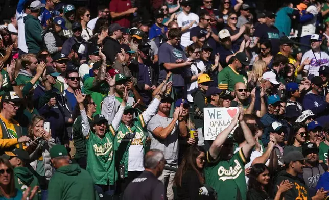 Fans cheer as former Seattle Mariners and Oakland Athletics player Rickey Henderson delivers the ceremonial first pitch before a baseball game between the Mariners and Athletics, Sunday, Sept. 29, 2024, in Seattle. (AP Photo/Lindsey Wasson)