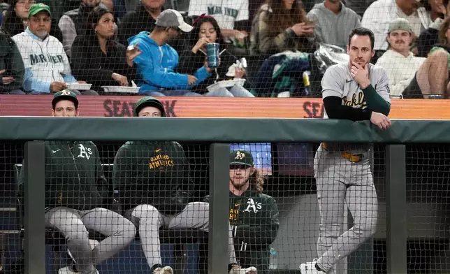 Oakland Athletics designated hitter Brent Rooker watches the game from the dugout railing during the sixth inning of a baseball game against the Seattle Mariners, Friday, Sept. 27, 2024, in Seattle. (AP Photo/Lindsey Wasson)