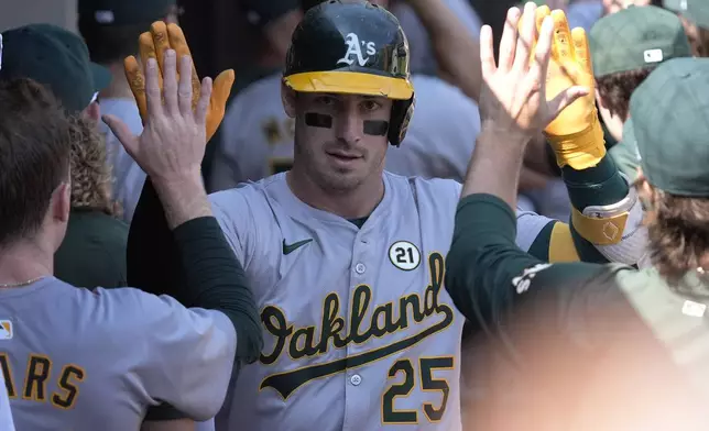 Oakland Athletics' Brent Rooker celebrates with teammates after hitting a two-run home run during the fifth inning of a baseball game against the Chicago White Sox in Chicago, Sunday, Sept. 15, 2024. (AP Photo/Nam Y. Huh)