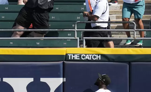 Fans try to grab a two-run home run ball hit by Oakland Athletics' Brent Rooker as Chicago White Sox center fielder Luis Robert Jr. (88) watches during the fifth inning of a baseball game in Chicago, Sunday, Sept. 15, 2024. (AP Photo/Nam Y. Huh)