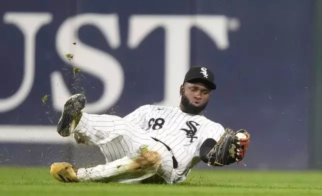 Chicago White Sox outfielder Luis Robert Jr. makes a sliding catch of a shallow fly ball by Oakland Athletics' Seth Brown during the sixth inning of a baseball game Friday, Sept. 13, 2024, in Chicago. (AP Photo/Charles Rex Arbogast)